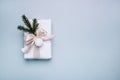 Gift, fir tree branches, white ribbon and ball light on blue background. Christmas, new year concept. Flat lay, top view Royalty Free Stock Photo