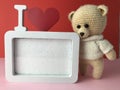 A gift for a girl on February 14. soft knitted bear on a red background with a cute frame in white. romantic sentimental gift for