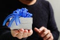 gift giving,man hand holding a gift box in a gesture of giving.blured background,bokeh effect Royalty Free Stock Photo