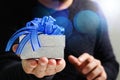 gift giving,man hand holding a gift box in a gesture of giving.blured background,bokeh effect Royalty Free Stock Photo