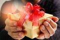 gift giving,man hand holding a gift box in a gesture of giving.blured background Royalty Free Stock Photo