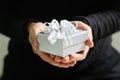 gift giving,man hand holding a gift box in a gesture of giving.blurred background,bokeh effect,vintage Royalty Free Stock Photo