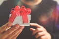 gift giving,man hand holding a gift box in a gesture of giving.blurred background,bokeh effect Royalty Free Stock Photo