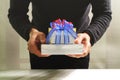 gift giving,man hand holding a gift box in a gesture of giving.blurred background,bokeh effect Royalty Free Stock Photo