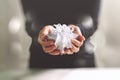 gift giving,man hand holding a gift box in a gesture of giving.blurred background,bokeh effect Royalty Free Stock Photo