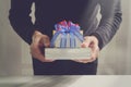 gift giving,man hand holding a gift box in a gesture of giving.blurred background,bokeh effect Royalty Free Stock Photo
