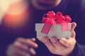 gift giving,man hand holding a gift box in a gesture of giving.blurred background,bokeh effect Royalty Free Stock Photo