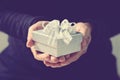 gift giving,man hand holding a gift box in a gesture of giving.blurred background,bokeh effect,vintage Royalty Free Stock Photo