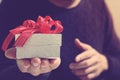 gift giving,man hand holding a gift box in a gesture of giving.blurred background,bokeh effect Royalty Free Stock Photo