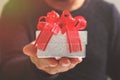 gift giving,man hand holding a gift box in a gesture of giving.blurred background,vintage effect Royalty Free Stock Photo