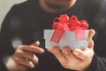 gift giving,man hand holding a gift box in a gesture of giving.blurred background,vintage effect Royalty Free Stock Photo