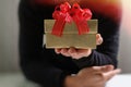 gift giving,man hand holding a gift box in a gesture of giving.blurred background,vintage effect Royalty Free Stock Photo