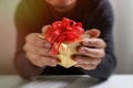 gift giving,man hand holding a gift box in a gesture of giving.blurred background,vintage effect Royalty Free Stock Photo