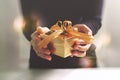 gift giving,man hand holding a gift box in a gesture of giving.blurred background,bokeh effect Royalty Free Stock Photo