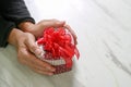 gift giving,man hand holding a heart shape gift box in a gesture Royalty Free Stock Photo