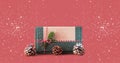 Gift green box with Christmas ornaments against background in poppy sunset shades with snowflakes. Concept for festive