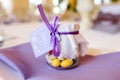 Gift for guests. Wedding bonbonniere-sweets in a jar covered with a white cloth with a bow . on a purple napkin.