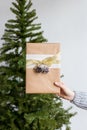 Gift in hand with christmas tree at background Royalty Free Stock Photo