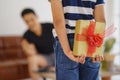 Gift in hand of kid hiding behind want to make surprise giving to father