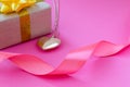 Gift, heart, ribbon on a pink background Royalty Free Stock Photo