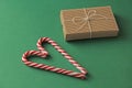 Gift Kraft Brown Color Box and Candy Canes Red and White in Heart Shape Lies on the Green Background, View From the Top. For your Royalty Free Stock Photo