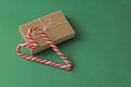 Gift Kraft Brown Color Box and Candy Canes Red and White in Heart Shape Lies on the Green Background, View From the Top. For your Royalty Free Stock Photo