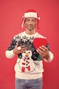Gift with love. sexy man santa earflap hat. man funny sweater red wall. warm your heart in winter. male share his heart