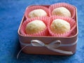 A gift made with love: four exquisite white chocolate and coconut truffles in a beautiful peach candy box.