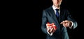 Gift man. Happy young businessman holding surprise gift box present with red ribbon isolated on black background. Black Royalty Free Stock Photo