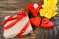 The gift is Packed in Kraft paper and tied with a red ribbon with a rose in the center of which lies a pendant in the shape of clo Royalty Free Stock Photo