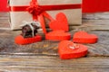 The gift is Packed in Kraft paper and tied with a red ribbon rose. Gift surrounded by decorative hearts one is a wedding ring with Royalty Free Stock Photo