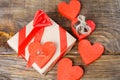 The gift is Packed in Kraft paper and tied with a red ribbon rose. Gift surrounded by decorative hearts one is a wedding ring with Royalty Free Stock Photo