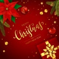 Gift with Poinsettia Flower and Bells on Red Christmas Background Royalty Free Stock Photo