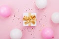 Gift or present box, balloons and confetti on pink pastel table top view. Flat lay composition for birthday, mother day or wedding Royalty Free Stock Photo