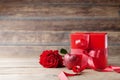 Gift or present box, heart and rose flower on wooden rustic table. Mother or Valentines day greeting card. Copy space for text.