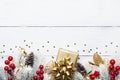 Gift or present box, snowy fir tree and Christmas decorations on white wooden table top view. Flat lay. Royalty Free Stock Photo