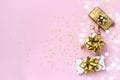 Gift or present boxes with gold bows, Christmas balls and confetti on a pink background, top view. Christmas and New Year card Royalty Free Stock Photo