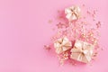 Gift or present boxes, golden ribbons and stars confetti on pink table top view. Flat lay festive composition for birthday Royalty Free Stock Photo