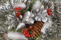 Gift, red berries and pine cones on a silvery tinsel