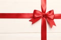 Gift red bow and ribbon on a white wooden background Royalty Free Stock Photo