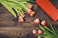 Gift red box and tulip flowers on a wooden table. Flat lay Royalty Free Stock Photo