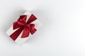 Gift with a red ribbon and a bow on a white background, copy space Royalty Free Stock Photo