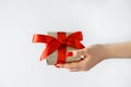 Gift with a red ribbon in hands on a white background