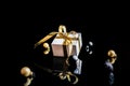 Gift ribbon gold. White gift box with golden ribbon, New Year balls and winter tree in Christmas composition on black Royalty Free Stock Photo