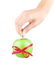 Gift ribbon tied with green apple and hand Royalty Free Stock Photo