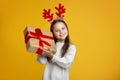 Gift from Santa Claus. Joyful girl holds present and listens to box Royalty Free Stock Photo