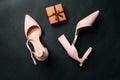 Gift and shoes on a dark background. Women stylish shoes and a gift box with a ribbon.