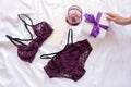 Gift, shopping and fashion concept. Set of glamorous stylish lace lingerie on bed with giftbox and wineglass on