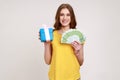 Gift shopping. Happy teenager girl in yellow T-shirt holding present box and euro money banknotes Royalty Free Stock Photo