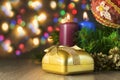 Gift with two candles and Christmas toy with multi-colored lights on background